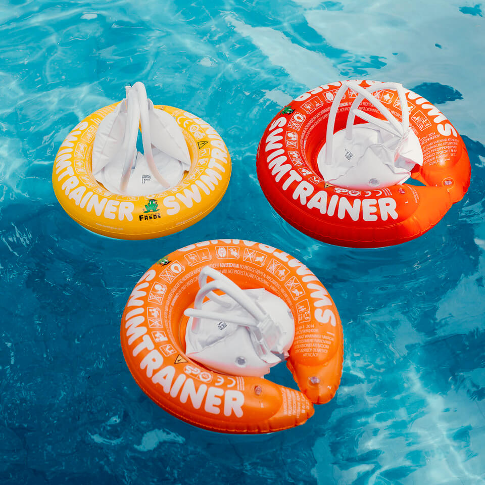 bouee-rouge-orange-jaune-swimtrainer-classique Vue des 3 bouées Swimtrainer classiques rouge, orange et jaune dans une piscine.